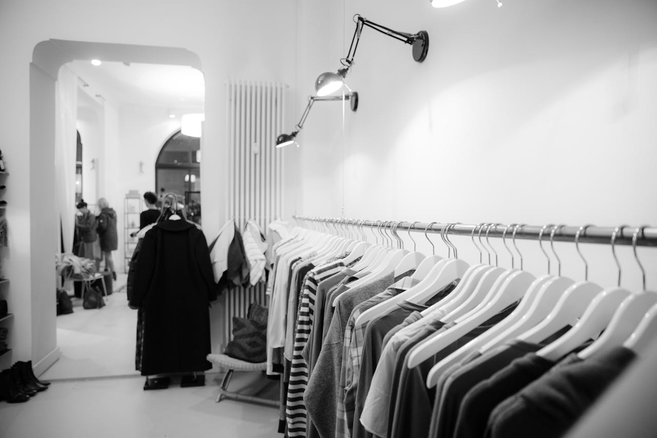 Home Stylish black and white interior of a boutique with clothes on racks, showcasing modern fashion.